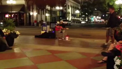 В огнях ночного города, живет.